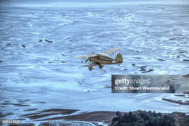 antique biplane over tideflats - everett stock-fotos und bilder