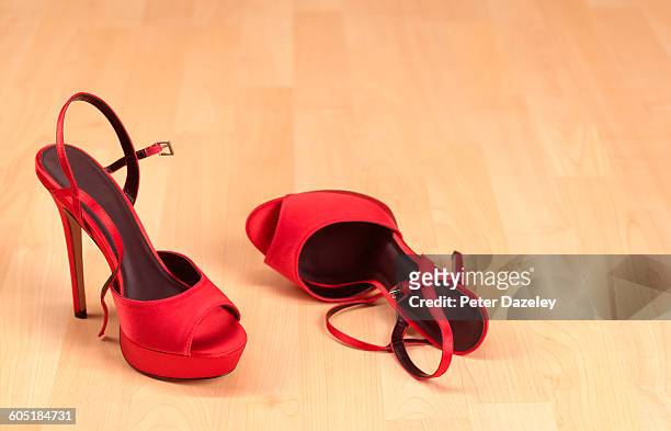 red stilettos on wooden floor - high heels stock pictures, royalty-free photos & images
