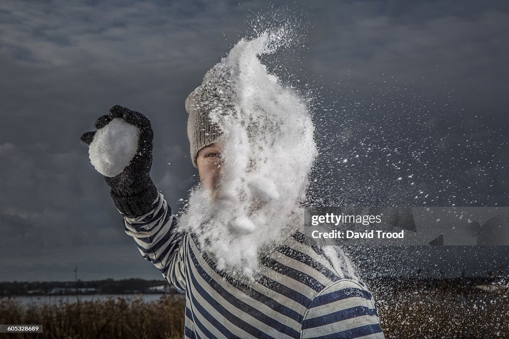 Man getting hit by snowball in the face