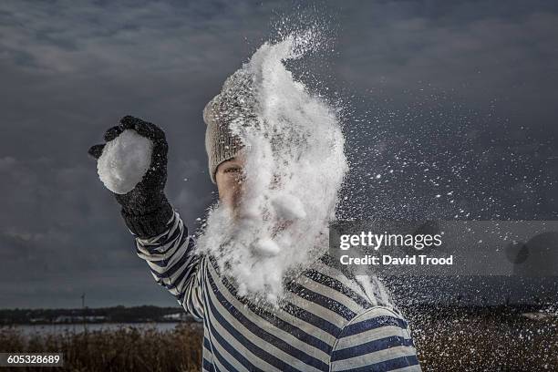 man getting hit by snowball in the face - gants de sport photos et images de collection