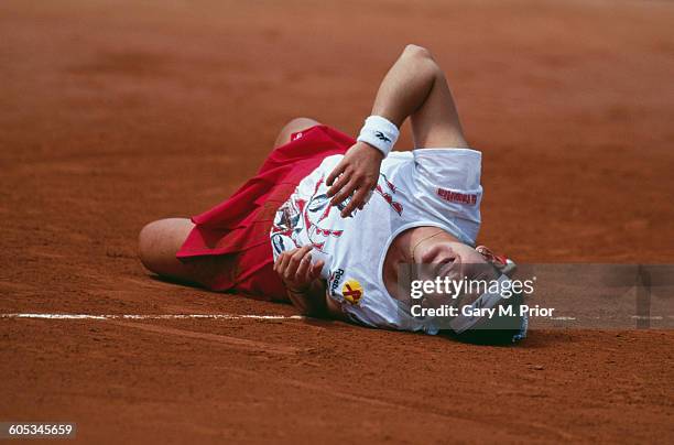 Arantxa Sanchez Vicario of Spain rolls on the ground in pain after she injures her wrist during the Women's Singles Fourth Round match against Anke...