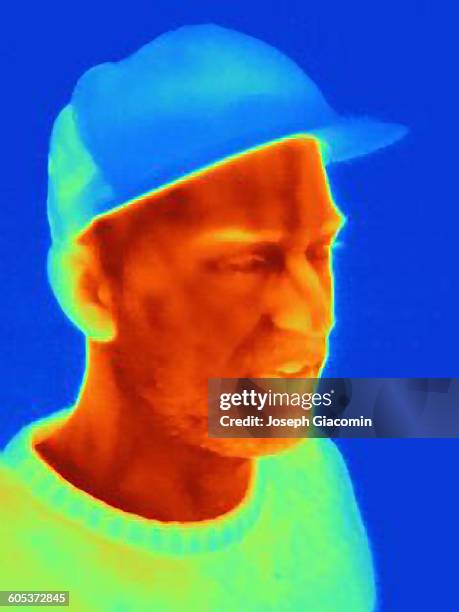 thermal image of young man wearing face mask and baseball cap - macho photos et images de collection
