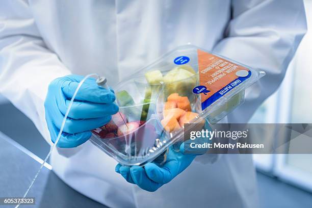 close up of scientist inspecting food for freshness in laboratory in food packaging printing factory - food packaging stock-fotos und bilder