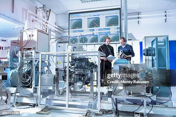 scientists in turbo charger automotive research laboratory - onderzoeksfaciliteit stockfoto's en -beelden