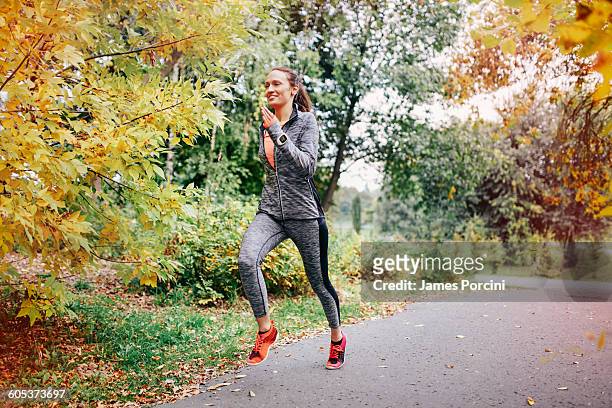 mid adult female runner running along park path - krakow park stock pictures, royalty-free photos & images