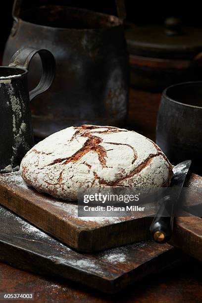 fresh baked organic bread, pain de campagne rond, on chopping board - bread knife stockfoto's en -beelden