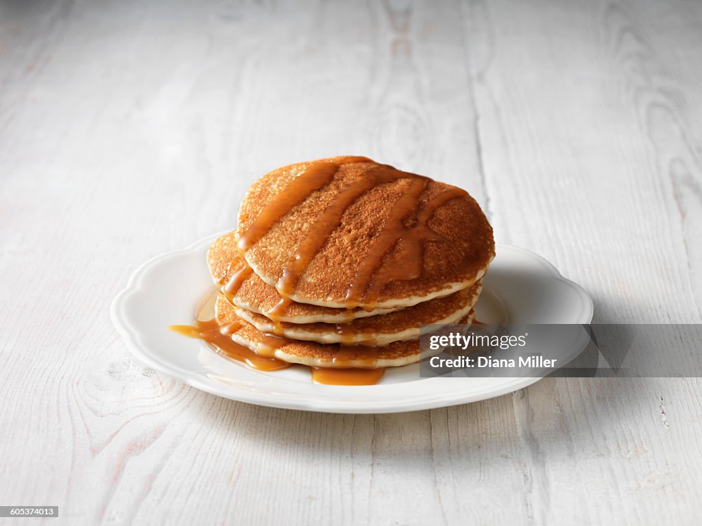 Stack of pancakes drizzled with butterscotch sauce
