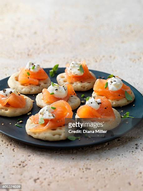 smoked salmon and cream cheese on blinis with chive and black pepper garnish - rökt lax bildbanksfoton och bilder