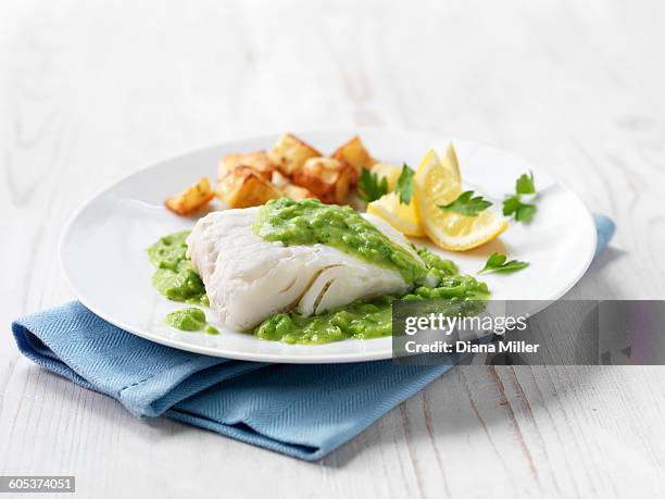 haddock fillet with fried potatoes, minted pea sauce and lemon wedges - savory sauce 個照片及圖片檔