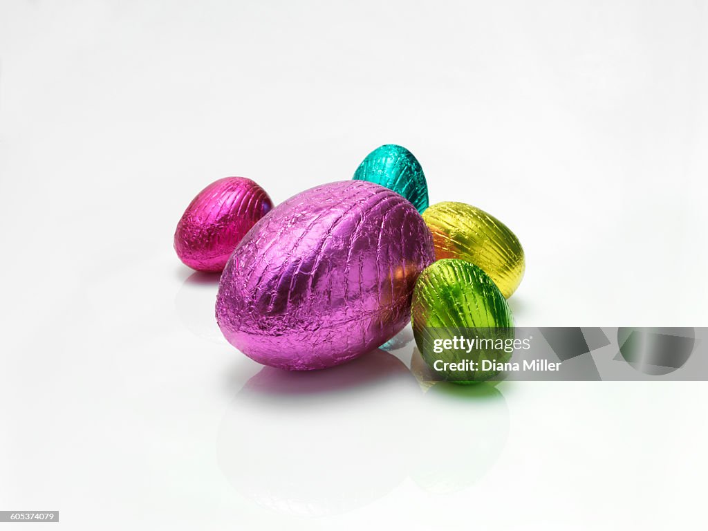 Colourful easter eggs in shiny foil on white background