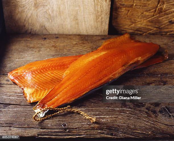 raw smoked salmon with skin on rustic wooden table - räucherlachs stock-fotos und bilder