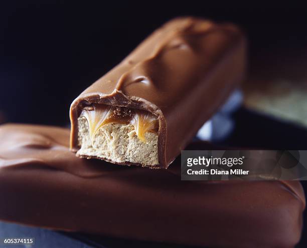 two stacked milk chocolate bars with caramel and nougat filling - nougat fotografías e imágenes de stock