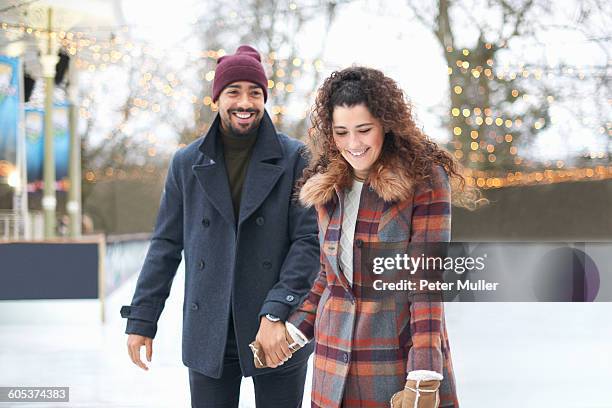 couple on ice rink holding hands smiling - couple skating stock pictures, royalty-free photos & images