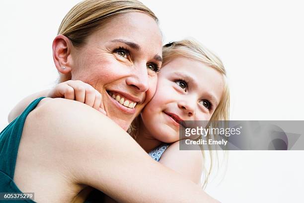 portrait of mid adult woman and daughter hugging in front of white wall - mother on white background stock pictures, royalty-free photos & images