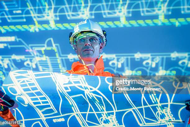 engineer with blueprint and projected plans - monty rakusen portrait stock pictures, royalty-free photos & images