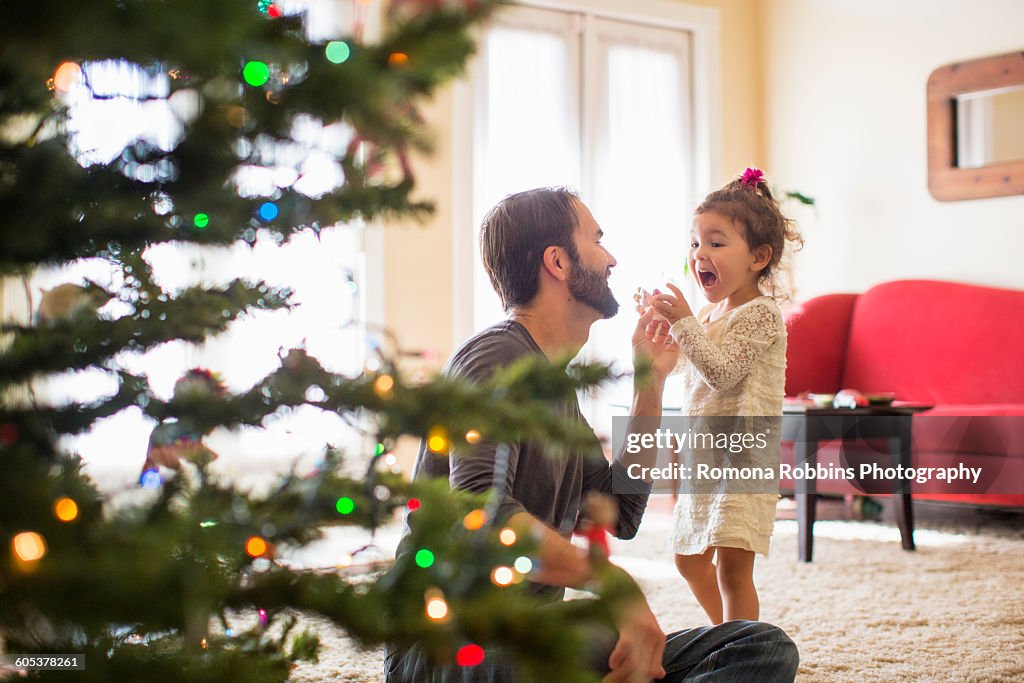 Father and daughter decorating christmas tree