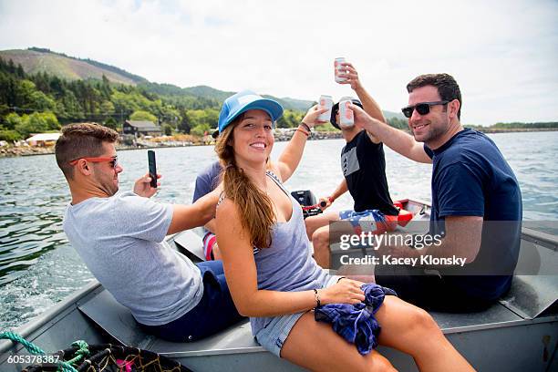 five adult friends raising a beer can on fishing boat at nehalem bay, oregon, usa - dosen schießen stock-fotos und bilder