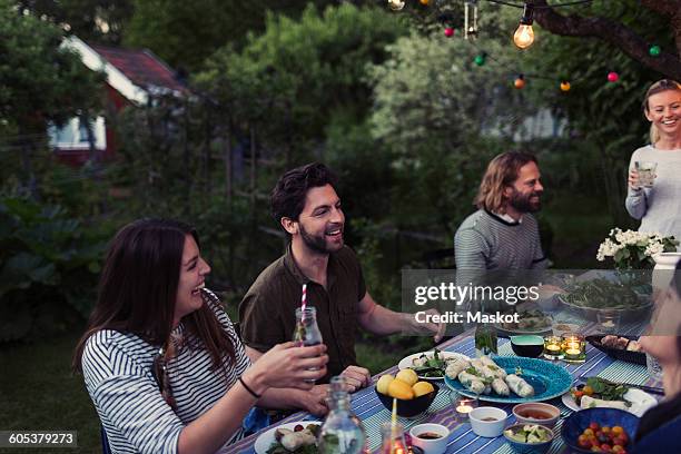 happy friends enjoying dinner party at yard - cocktail party home stock pictures, royalty-free photos & images