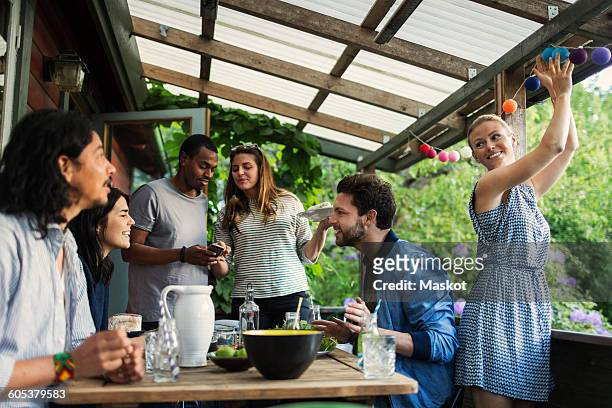 happy friends enjoying summer party in log cabin - cenador fotografías e imágenes de stock