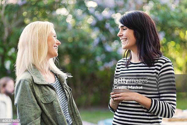 happy female friends talking at summer party - two people talking outside stock pictures, royalty-free photos & images
