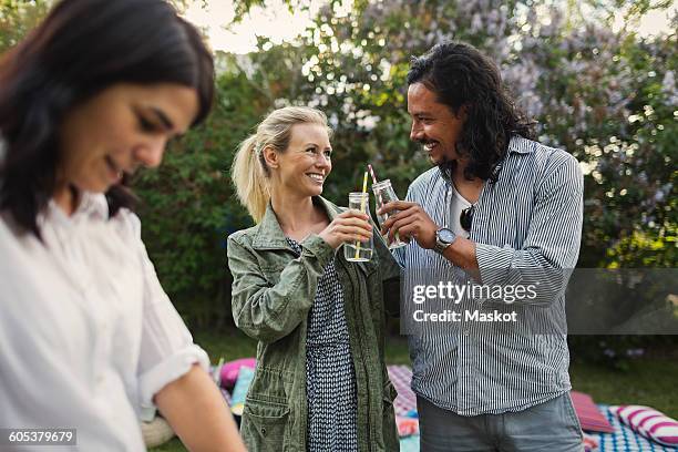 happy couple toasting drink bottles during summer party in yard - couple party bildbanksfoton och bilder