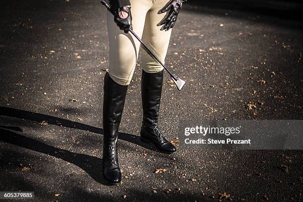 woman wearing riding boots, holding riding crop, low section - riding crop stock pictures, royalty-free photos & images