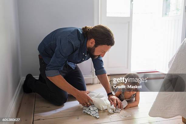mid adult father cleaning floor by baby boy at home - baby wash cloth stock pictures, royalty-free photos & images