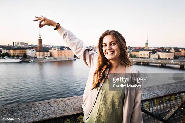optical illusion of happy female tourist holding building in city - forced perspective stock pictures, royalty-free photos & images