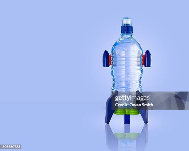 upright water bottle rocket with blue background - bottle rocket stock-fotos und bilder