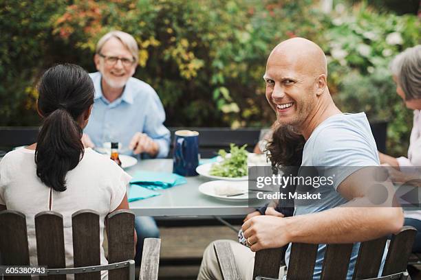 side view portrait of happy man enjoying meal with family at outdoor table - dinner on the deck stock pictures, royalty-free photos & images