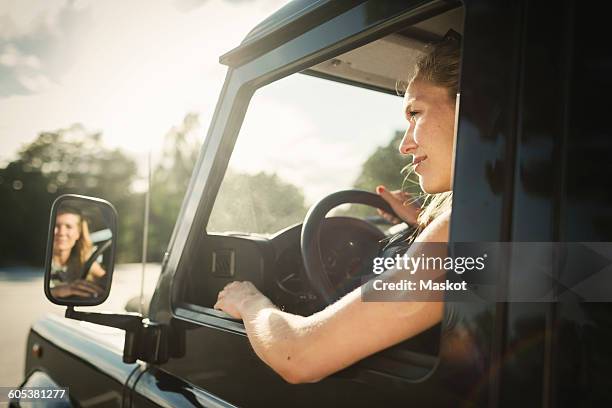 cropped image of woman looking away while driving car - side view mirror foto e immagini stock