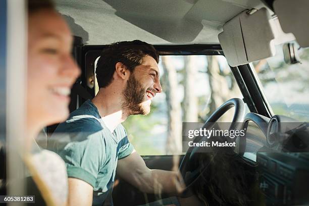 side view of happy couple enjoying road trip - voiture conducteur photos et images de collection