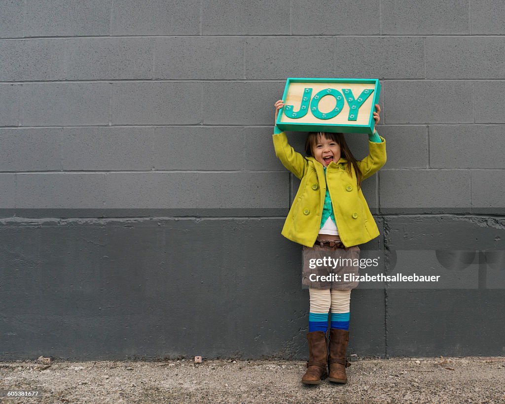 Happy girl holding a joy sign