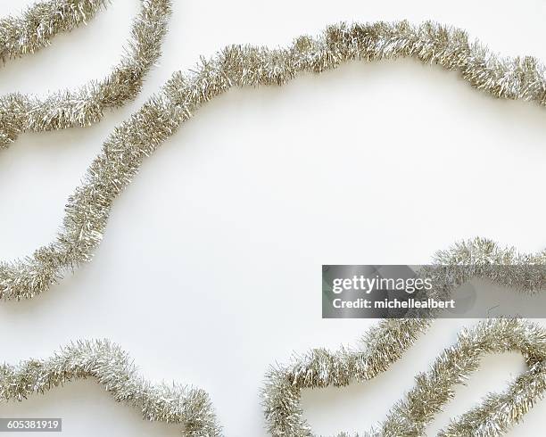 silver tinsel on a white background - christmas border stock pictures, royalty-free photos & images