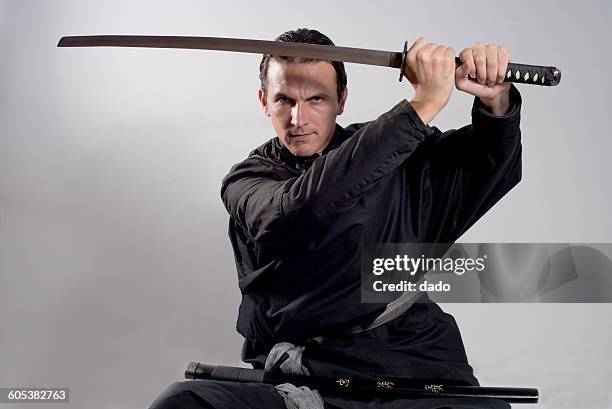 man dressed as a samurai holding katana in the air - fighter portraits 2015 stock pictures, royalty-free photos & images