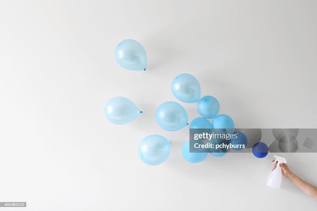 Conceptual woman holding a spray bottle spraying water