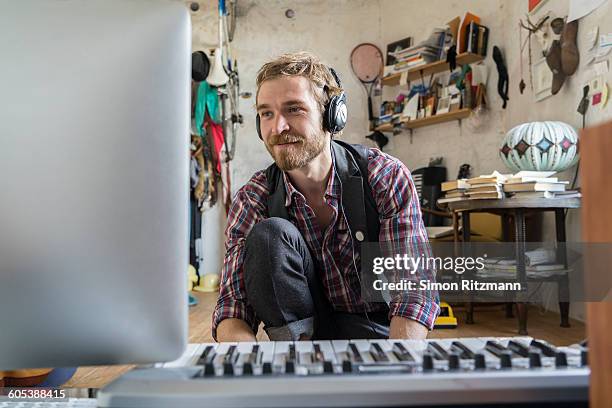 young man composing a piece of music with computer - men hobbies stock pictures, royalty-free photos & images