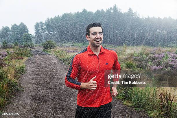 jogger running on path in rain. - man jogging stock pictures, royalty-free photos & images