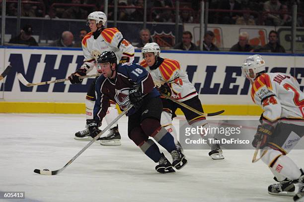 Forward Chris Drury of the Colorado Avalanche carries the puck up ice as Daniel Wagstrom and Daniel Rudslatt of Bryans look to pursue during the...
