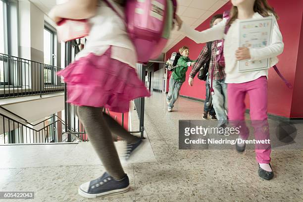 school students running in corridor, bavaria, germany - leren rok stockfoto's en -beelden