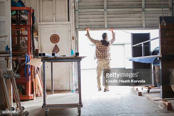 blue collar male working in wood / metal workshop. - よろい戸 ストックフォトと画像
