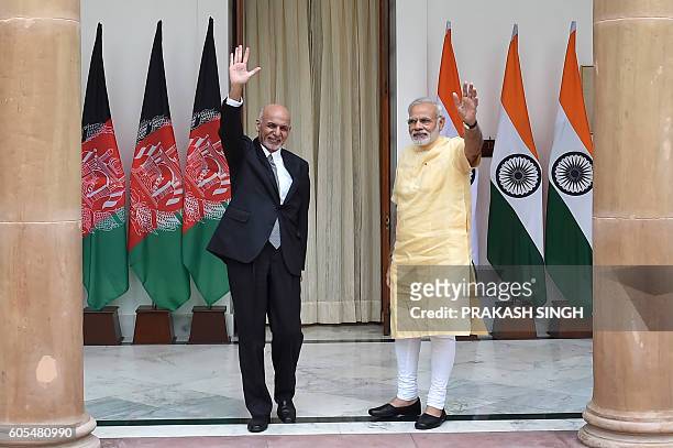 Afghan President, Asharf Ghani and Indian Prime Minister Narendra Modi wave during a photo call prior to a meeting in New Delhi on September 14,...