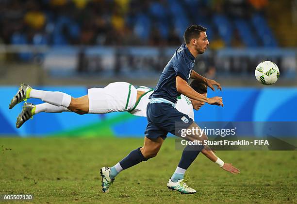 Jonathan Calleri of Argentina is challenged by Ayoub Abdellaoui of Algeria during the Olympic Men's Football match between Argentina and Algeria at...