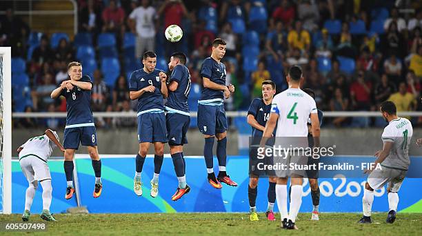 Zakarya Haddouchhe of Algeria takes a free kick against a wall of Argentenian players during the Olympic Men's Football match between Argentina and...