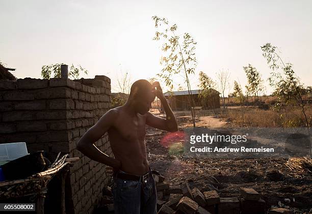 Dinesi Majawa pauses after watering his garden at his family home in the village of Masale, which lies in one of the areas most affected by drought,...