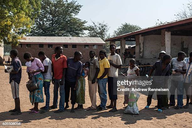 People wait in line for food aid at a school in the village of Malikopo, which lies in one of the areas most affected by drought, on September 9,...