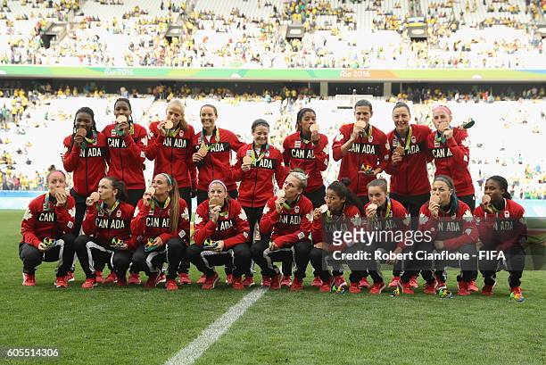 The Canadiam team pose with their bronze medals during the Women's Football Bronze Medal match between Brazil and Canada on Day 14 of the Rio 2016...