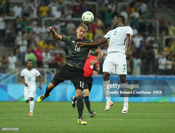 Nils Petersen of Germany and Muenfuh Sincere of Nigeria compete for the ball during the Men's Football Semi Final between Nigeria and Germany on Day...