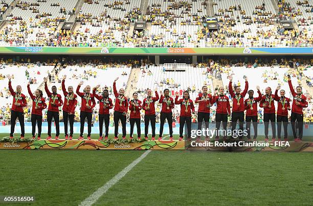 The Canadiam team pose with their bronze medals during the Women's Football Bronze Medal match between Brazil and Canada on Day 14 of the Rio 2016...