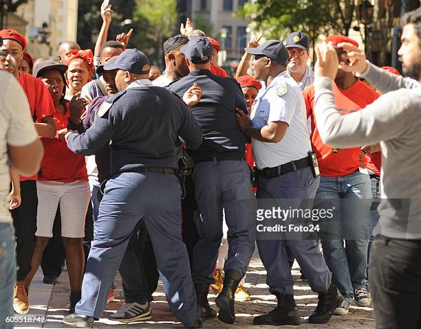 Economic Freedom Fighters members quarrel with police outside parliament during the National Assemblys President Jacob Zuma Question and Answer...